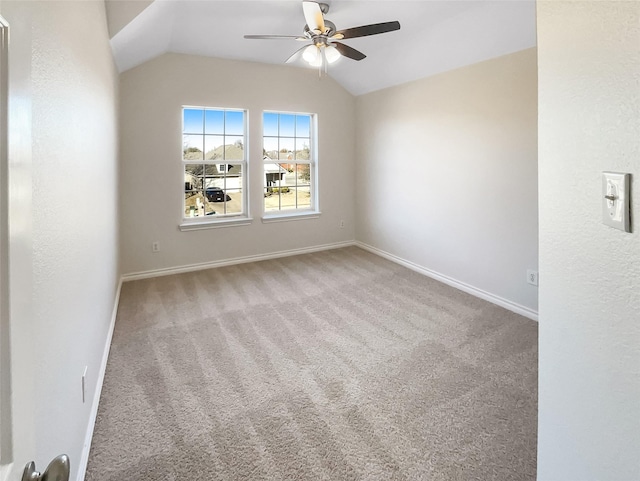 empty room featuring ceiling fan, carpet flooring, and vaulted ceiling