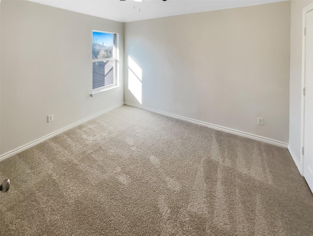 spare room with ceiling fan and carpet