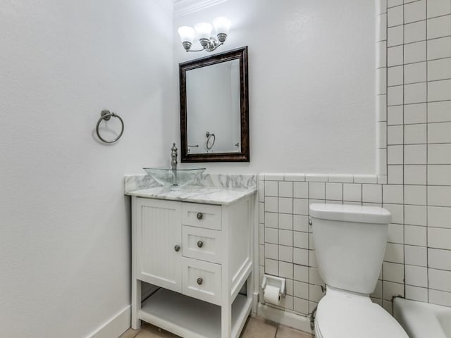 bathroom featuring vanity, toilet, tile patterned flooring, and tile walls