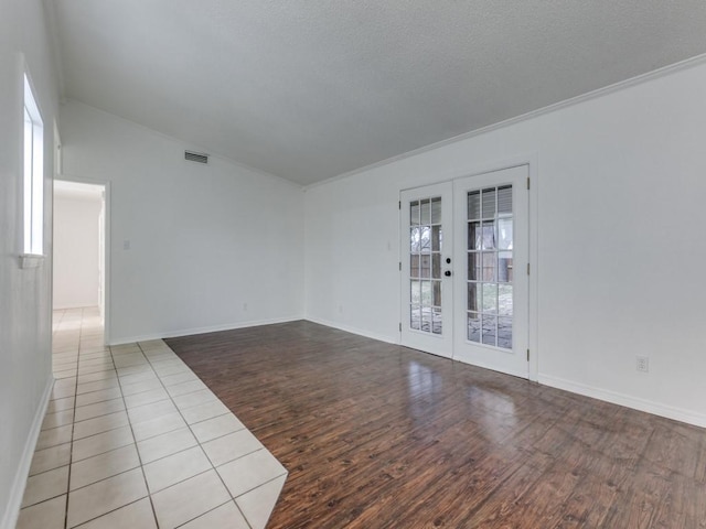 spare room featuring french doors, vaulted ceiling, and light hardwood / wood-style flooring