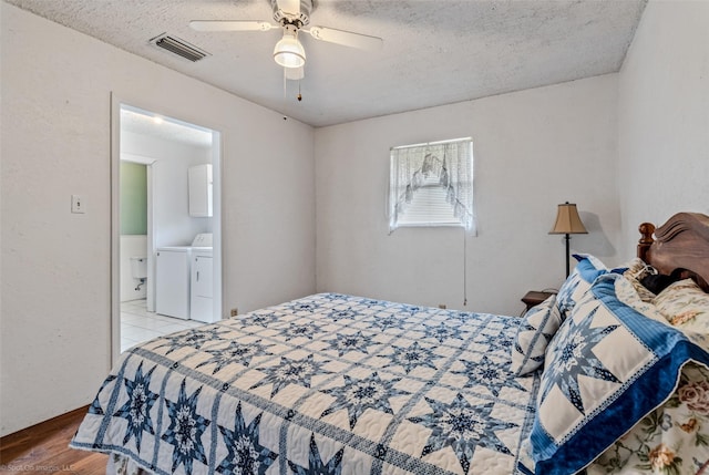 bedroom featuring hardwood / wood-style floors, a textured ceiling, washer and clothes dryer, and ceiling fan