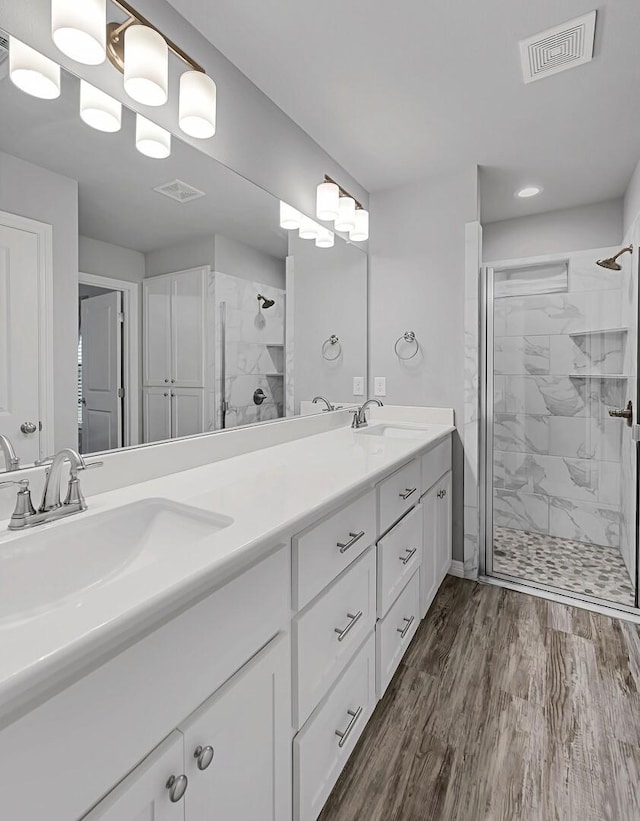 bathroom with a shower with door, hardwood / wood-style flooring, and vanity