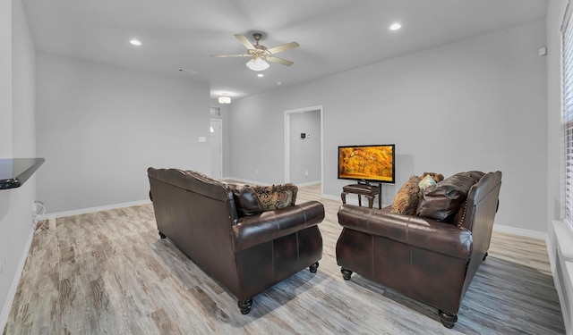 living room with light hardwood / wood-style flooring and ceiling fan