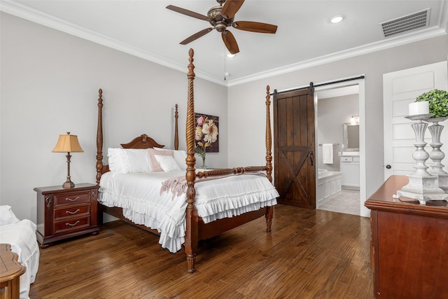 bedroom with ceiling fan, a barn door, ornamental molding, and ensuite bath