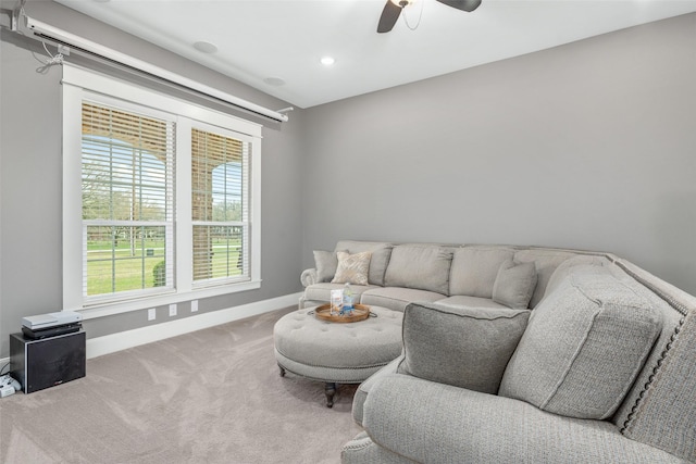 carpeted living room with ceiling fan