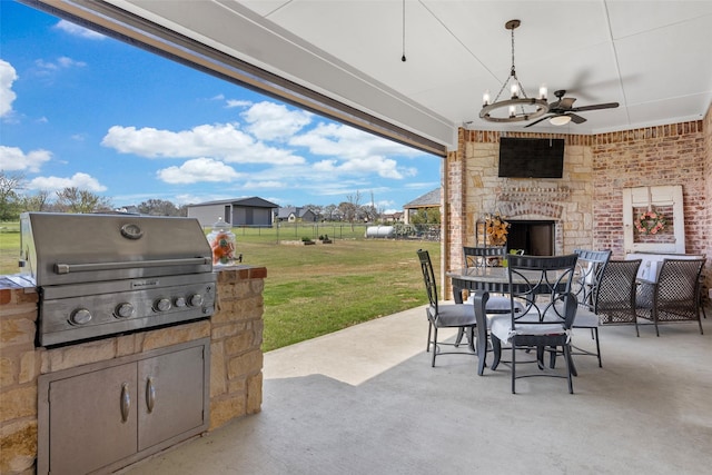 view of patio / terrace featuring an outdoor kitchen, ceiling fan, a grill, and an outdoor stone fireplace