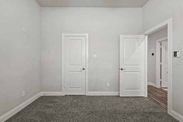 spare room with dark carpet