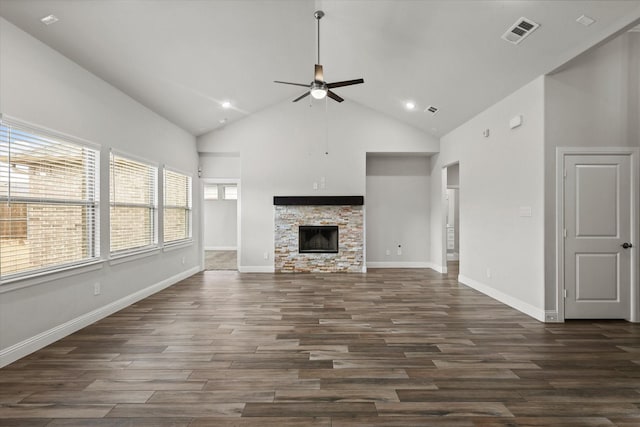 unfurnished living room with ceiling fan, dark wood-type flooring, high vaulted ceiling, and a stone fireplace