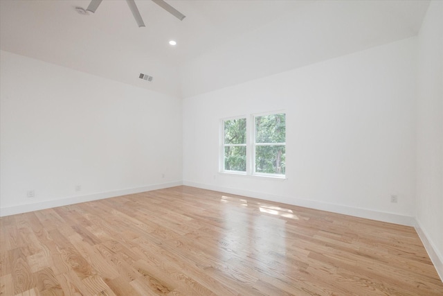 spare room featuring light wood-type flooring, vaulted ceiling, and ceiling fan