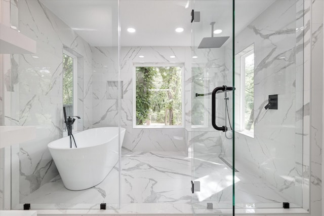 bathroom featuring independent shower and bath, tile walls, and plenty of natural light