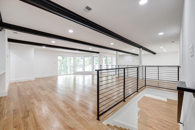 stairs featuring wood-type flooring and beam ceiling