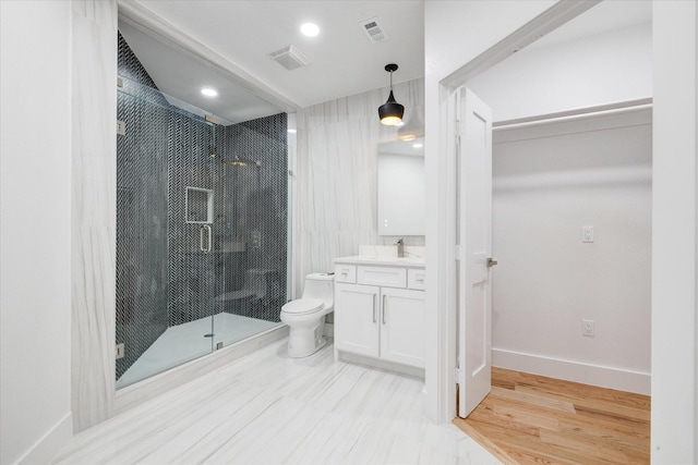 bathroom featuring hardwood / wood-style flooring, toilet, an enclosed shower, and vanity