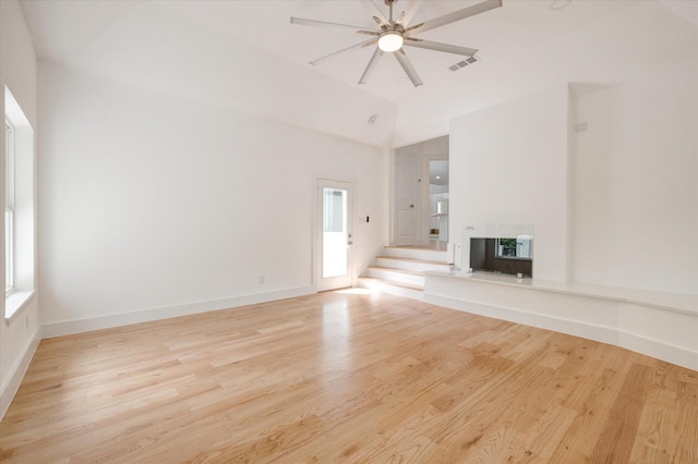 unfurnished living room with light wood-type flooring and vaulted ceiling