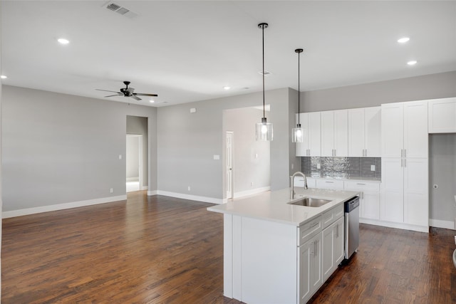 kitchen with dishwasher, white cabinetry, hanging light fixtures, sink, and an island with sink