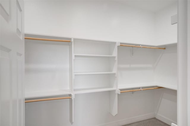 spacious closet featuring carpet flooring and built in desk