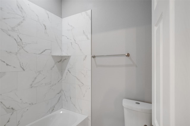 bathroom with tiled shower / bath combo and toilet