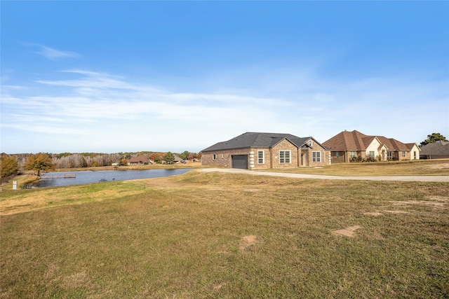 ranch-style house featuring a garage, a front lawn, and a water view