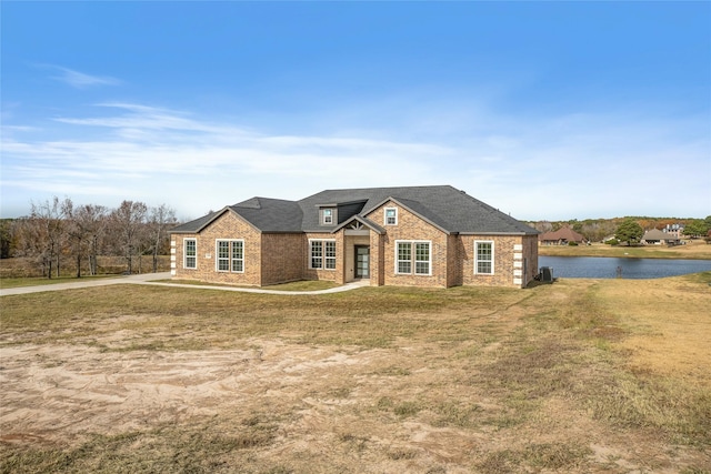 ranch-style house featuring a garage, a water view, and a front lawn