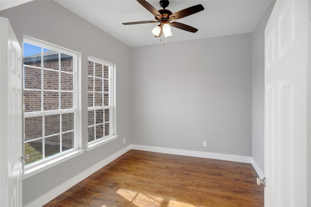 unfurnished room featuring ceiling fan, a wealth of natural light, and dark hardwood / wood-style flooring