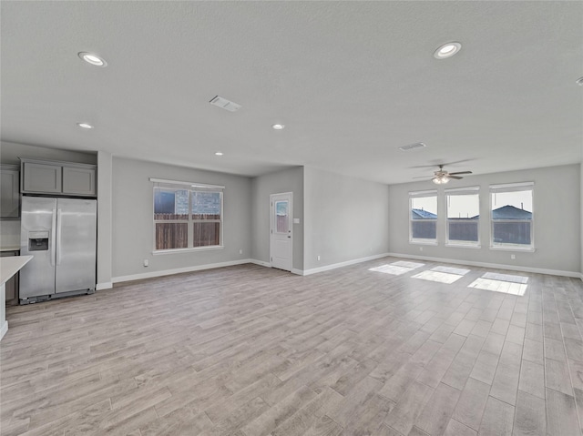 unfurnished living room featuring light hardwood / wood-style flooring and ceiling fan