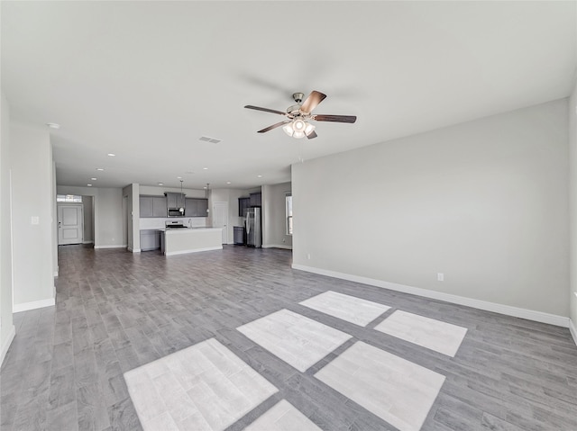 unfurnished living room with hardwood / wood-style floors and ceiling fan