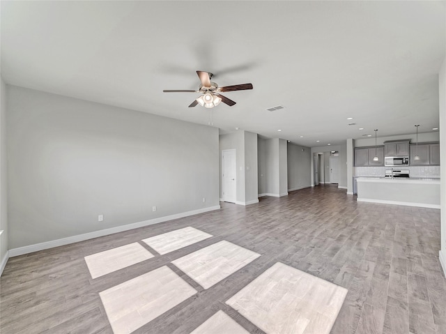 unfurnished living room with ceiling fan and light hardwood / wood-style flooring