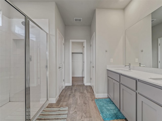 bathroom with vanity, a shower with door, and hardwood / wood-style floors