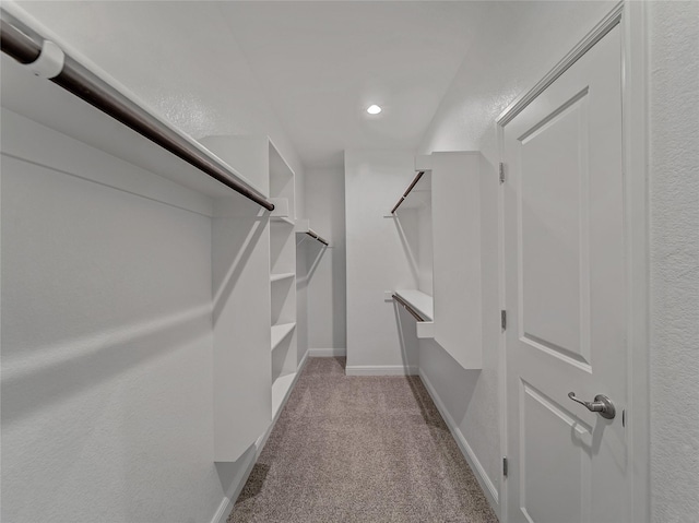 walk in closet featuring light colored carpet