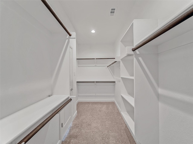 walk in closet featuring light carpet