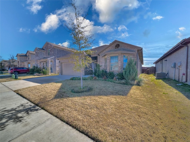 view of front of house with a garage, central AC, and a front yard