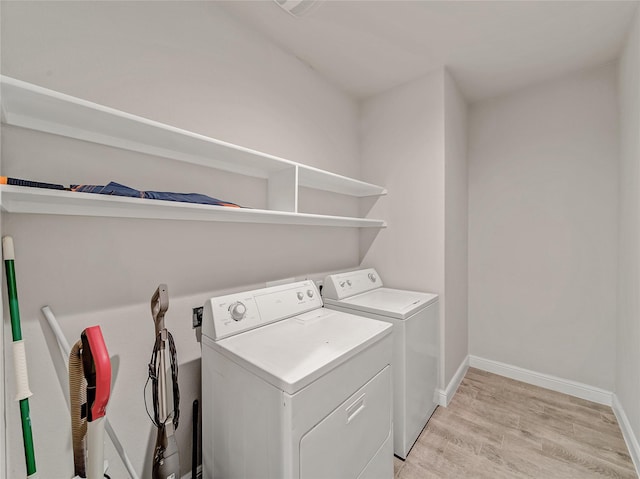 laundry room with washer and clothes dryer and light wood-type flooring