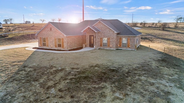 view of front of house featuring a front lawn and a rural view