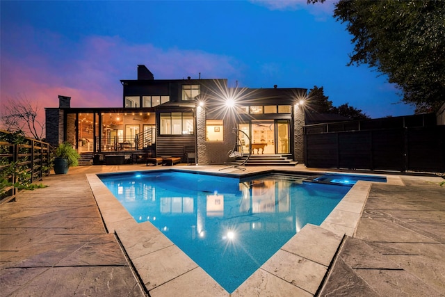 pool at dusk with a patio