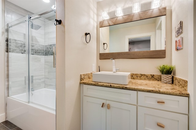 bathroom featuring bath / shower combo with glass door and vanity