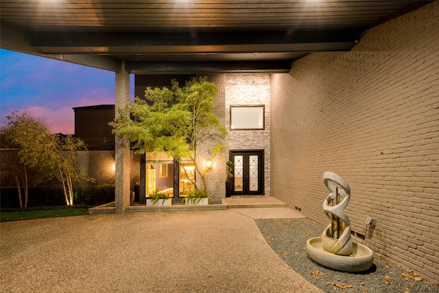 exterior entry at dusk with a patio area