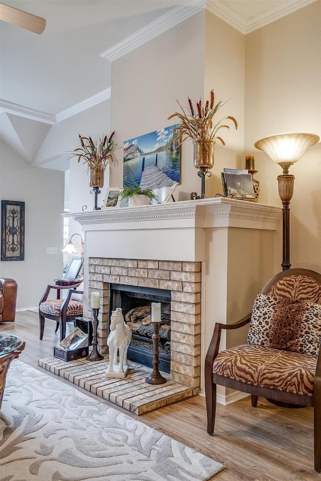 living area with a brick fireplace, wood-type flooring, and crown molding