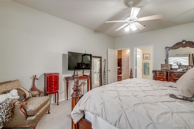 bedroom with ceiling fan, light colored carpet, and ensuite bathroom