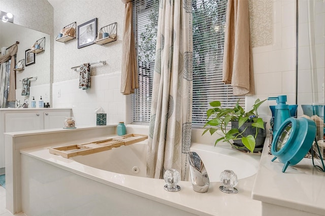 bathroom featuring a washtub and tile walls