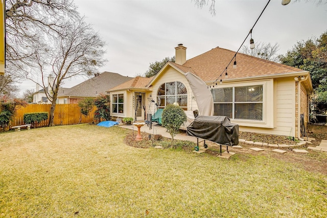 rear view of property featuring a lawn and a patio