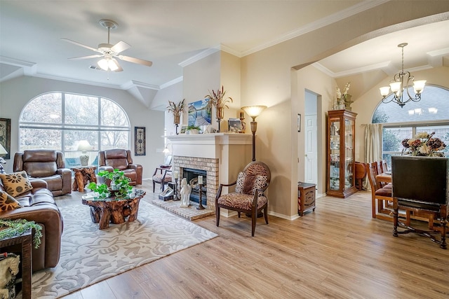 living room with light hardwood / wood-style floors, vaulted ceiling, ornamental molding, and plenty of natural light