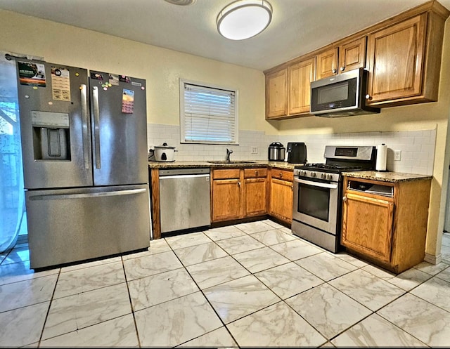 kitchen with appliances with stainless steel finishes, sink, and decorative backsplash