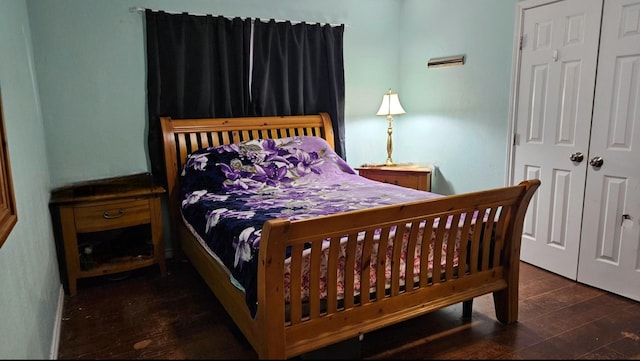 bedroom with dark hardwood / wood-style floors and a closet