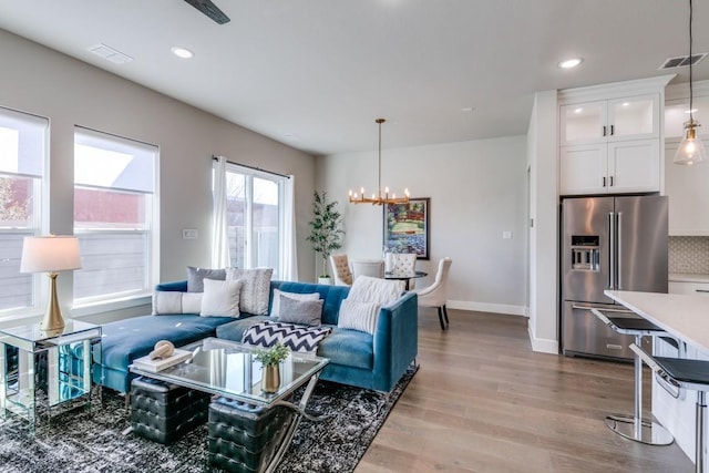 living room featuring light wood-type flooring and a chandelier