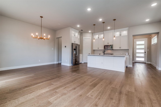 7836 Minglewood Ln, Dallas, TX 75231 - kitchen featuring appliances with stainless steel finishes, a chandelier, open floor plan, recessed lighting, and baseboards