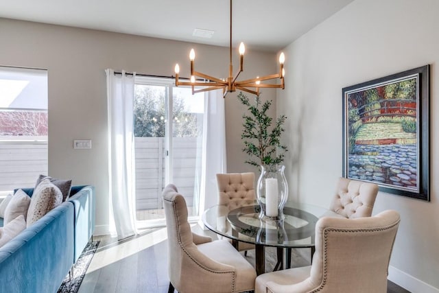 dining space featuring hardwood / wood-style floors and a notable chandelier