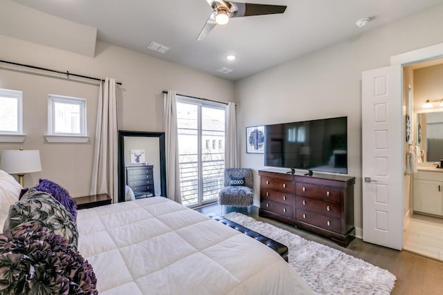 bedroom with ceiling fan, ensuite bathroom, and hardwood / wood-style flooring