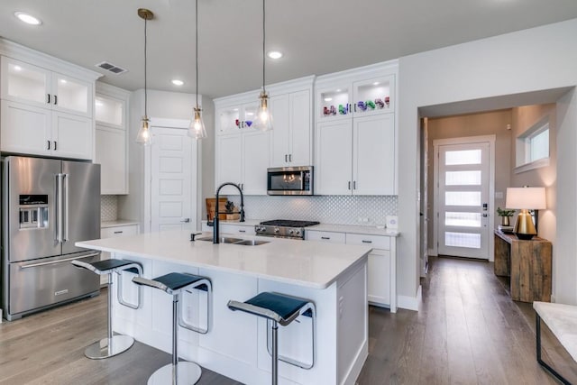 kitchen featuring sink, backsplash, white cabinets, and high quality appliances