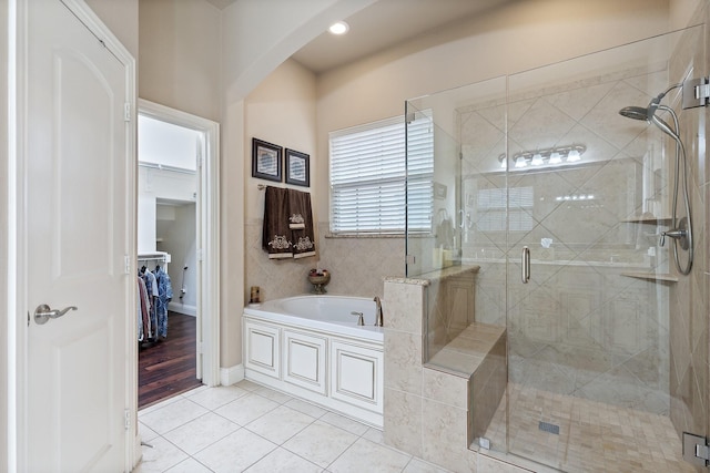 bathroom with shower with separate bathtub and tile patterned flooring