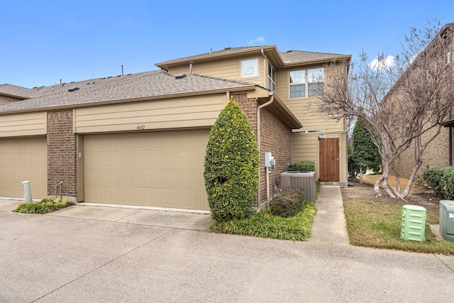 view of front facade featuring a garage and cooling unit