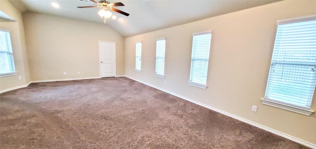 empty room featuring vaulted ceiling, ceiling fan, and carpet flooring